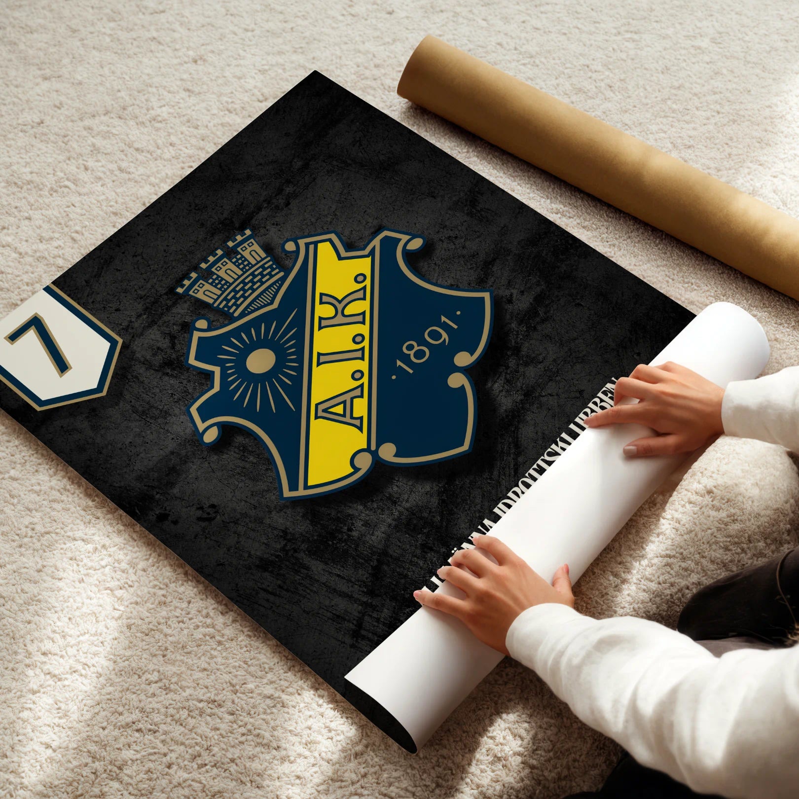 Person unrolling a large AIK logo poster on a light-colored floor