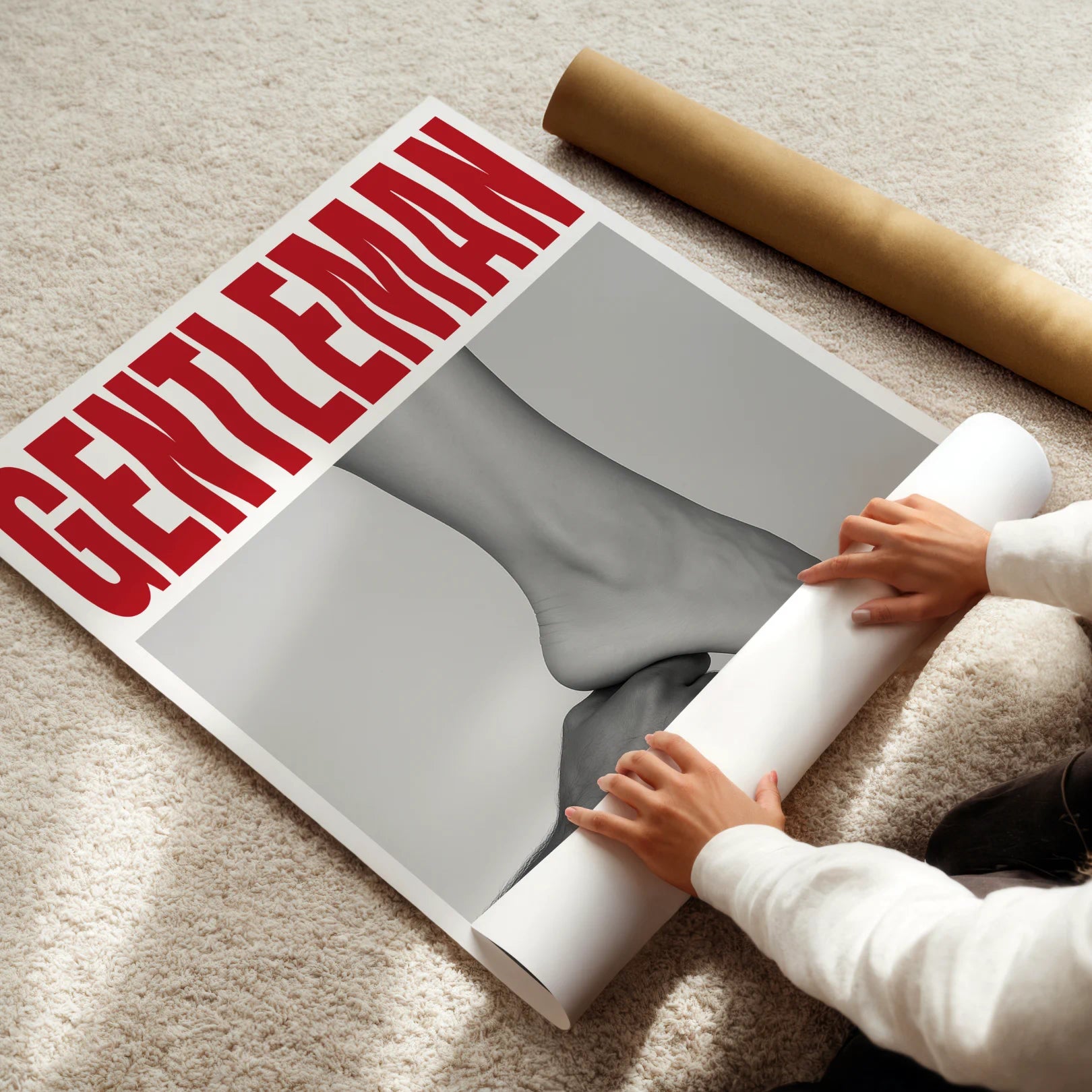 Person unrolling a large poster with 'Gentleman' magazine cover on a carpeted floor.