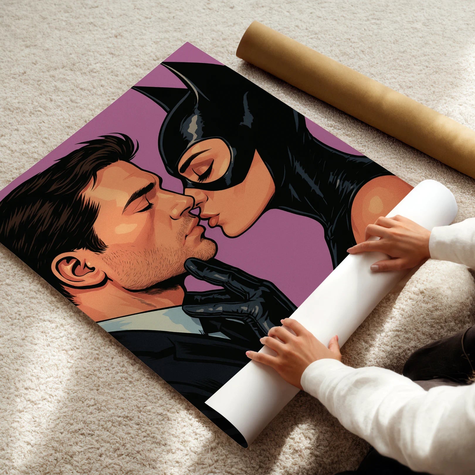 Person unrolling a cat woman poster of a couple kissing, with one person wearing a black mask and costume.