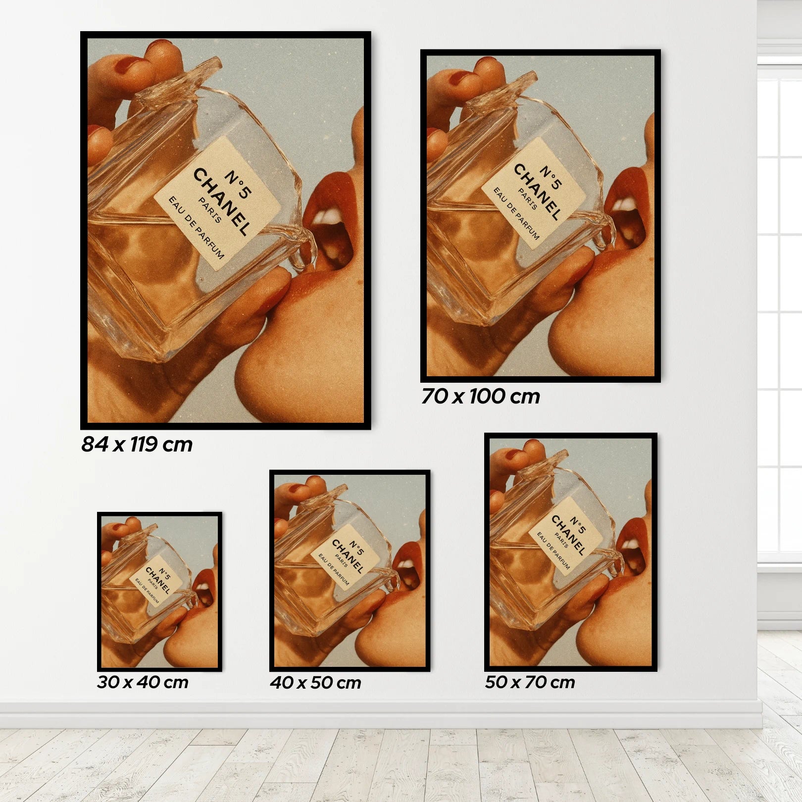 Set of framed posters showing a close-up of a Chanel perfume bottle held by hands.
