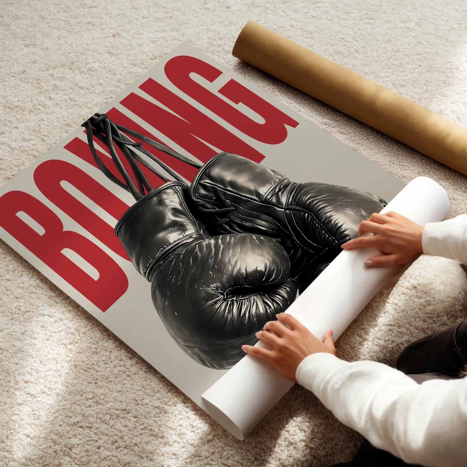 Person rolling up a poster with boxing gloves on a floor