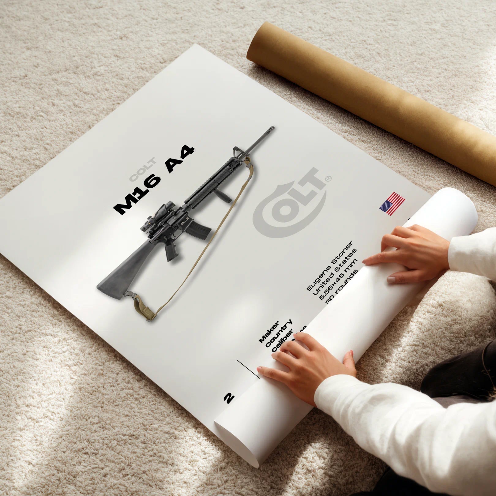 Person rolling out a poster of a Colt M16 A4 rifle on a carpeted floor.