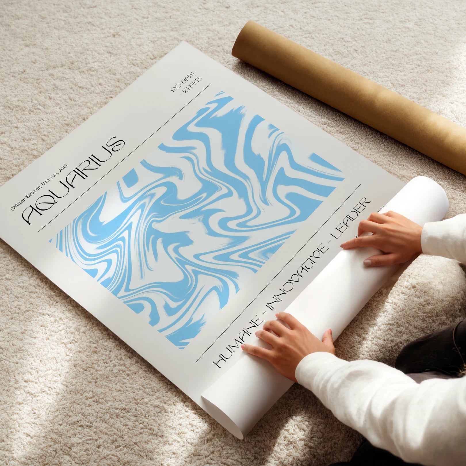 Person unrolling a large astrological poster titled 'Aquarius' on a carpeted floor.