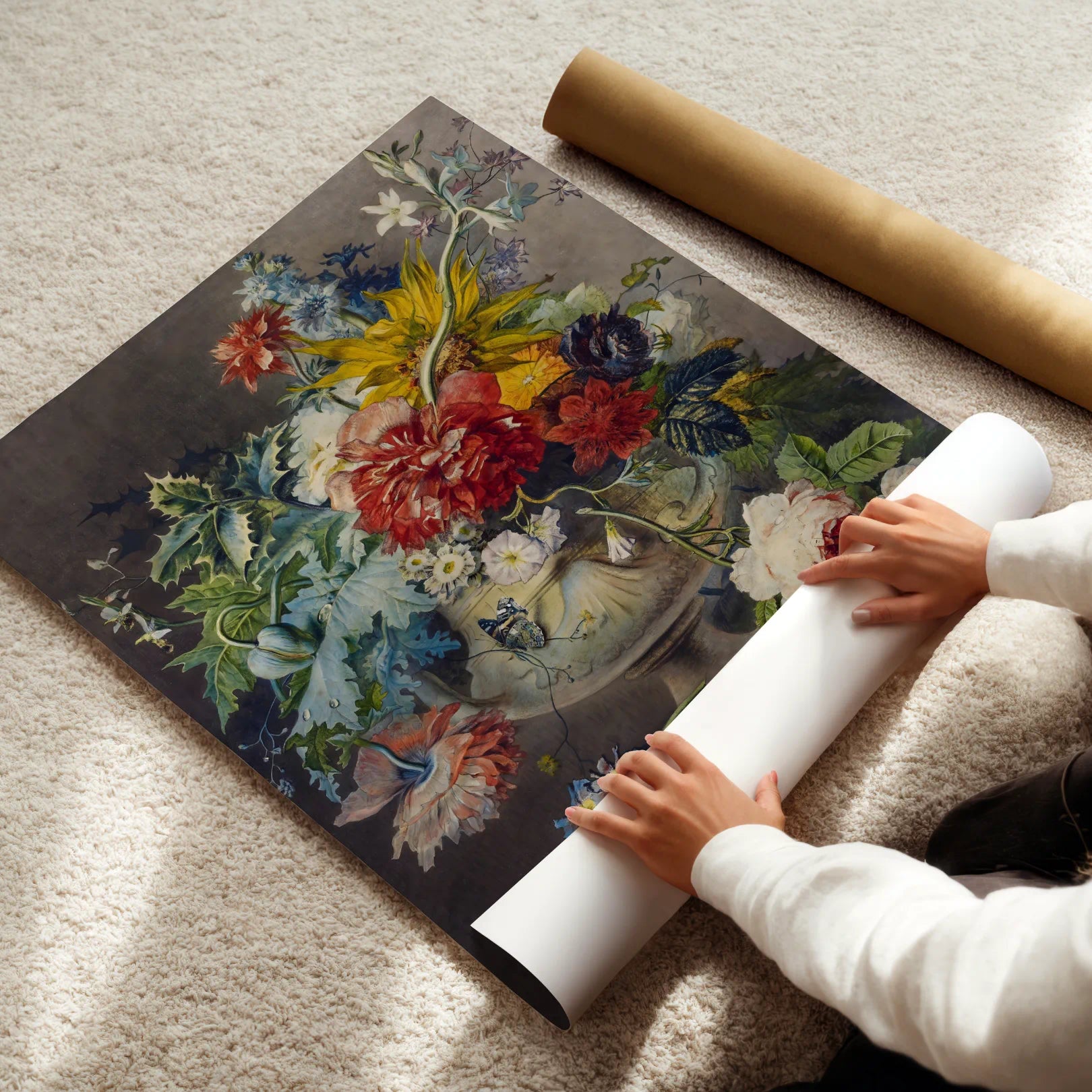 Person unrolling a floral poster on a carpeted floor
