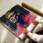 Person unrolling a large poster with a colorful abstract portrait on a light-colored floor.