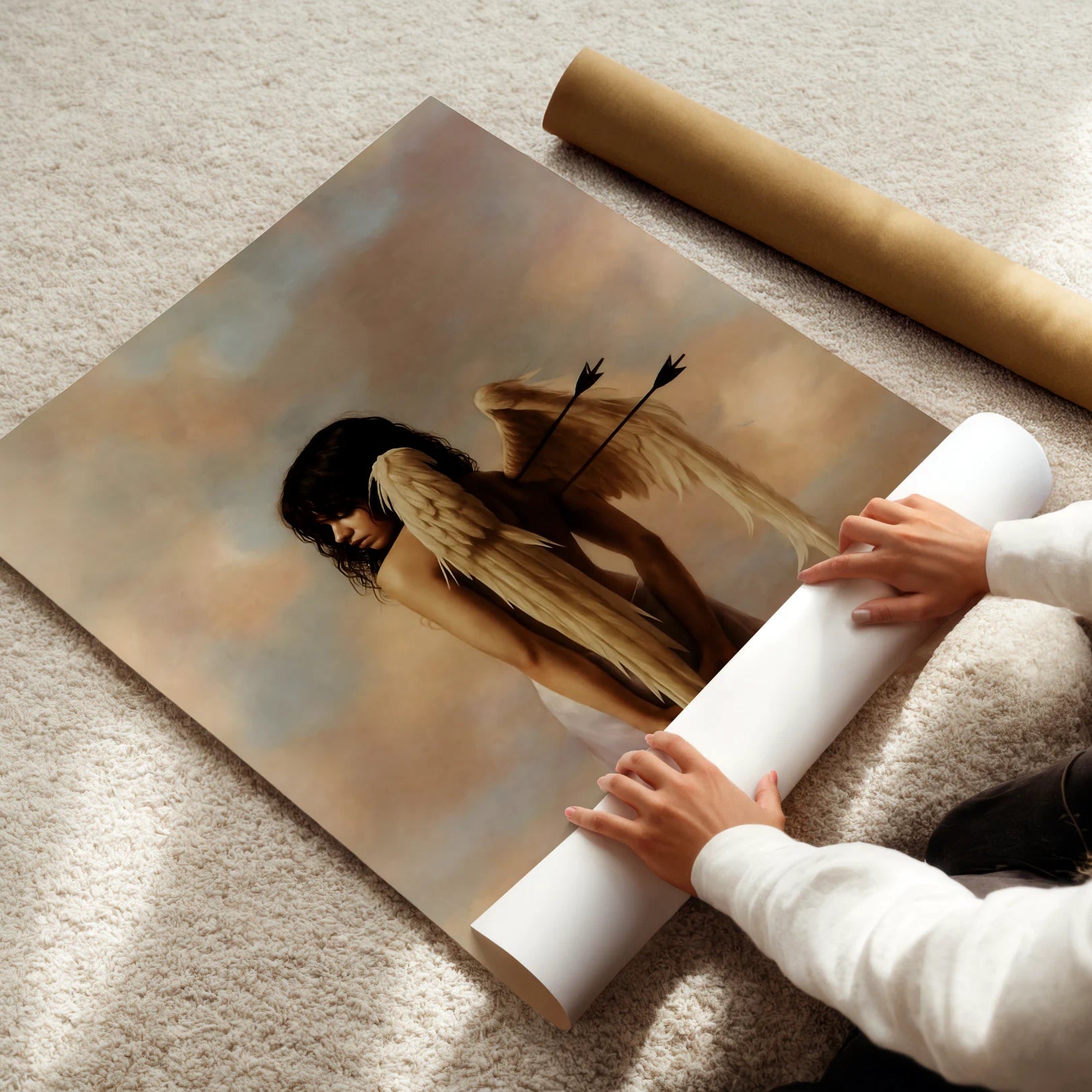 Person unrolling a large photo of a angel with wings on a carpeted floor.