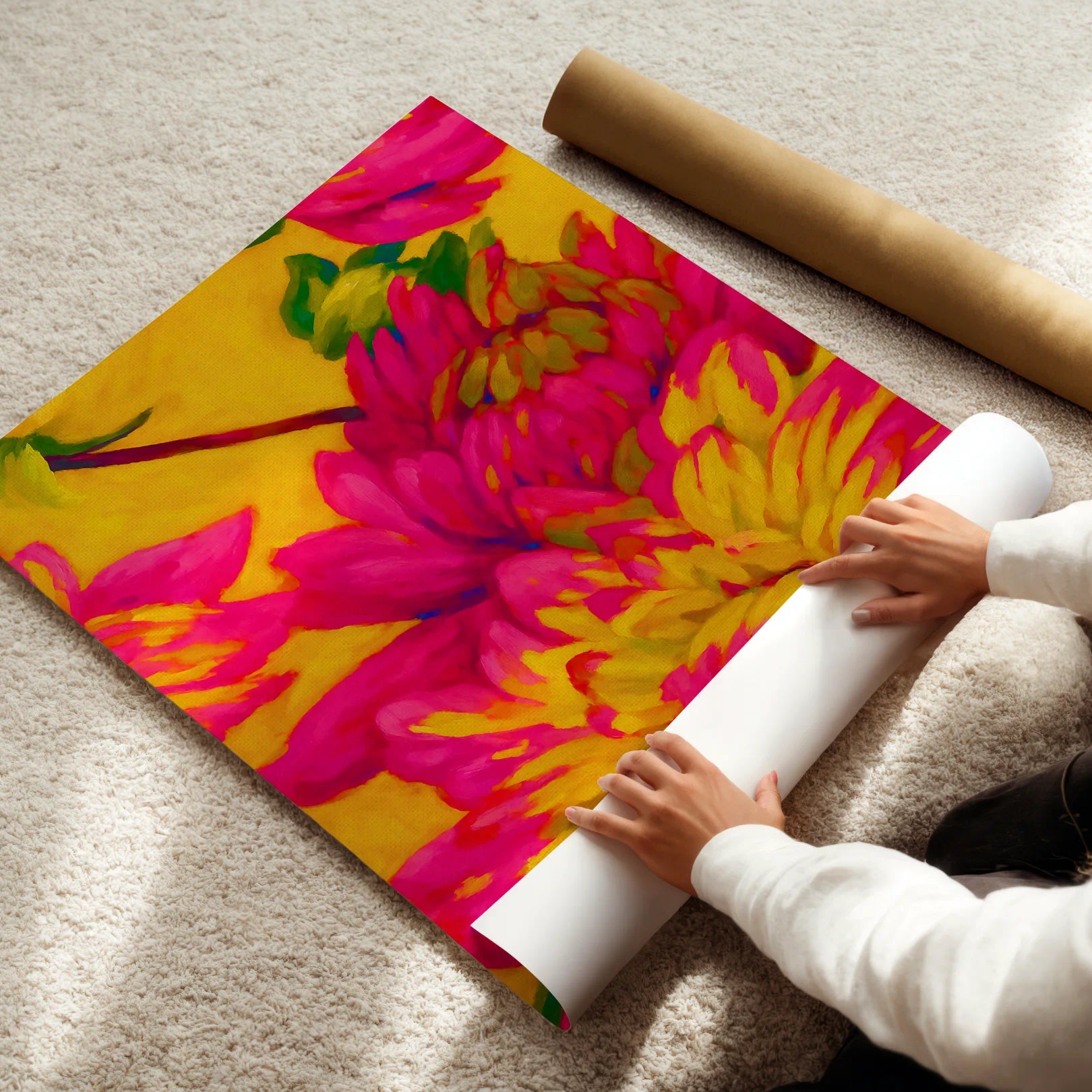 Person unrolling a colorful floral poster on a carpeted floor
