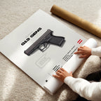 Person unrolling a poster of a glock gun on a carpeted floor