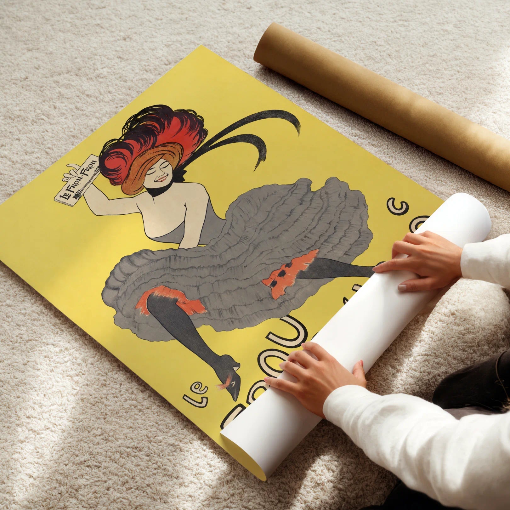 Person unrolling a large poster of a stylized woman with red hair on a yellow background.