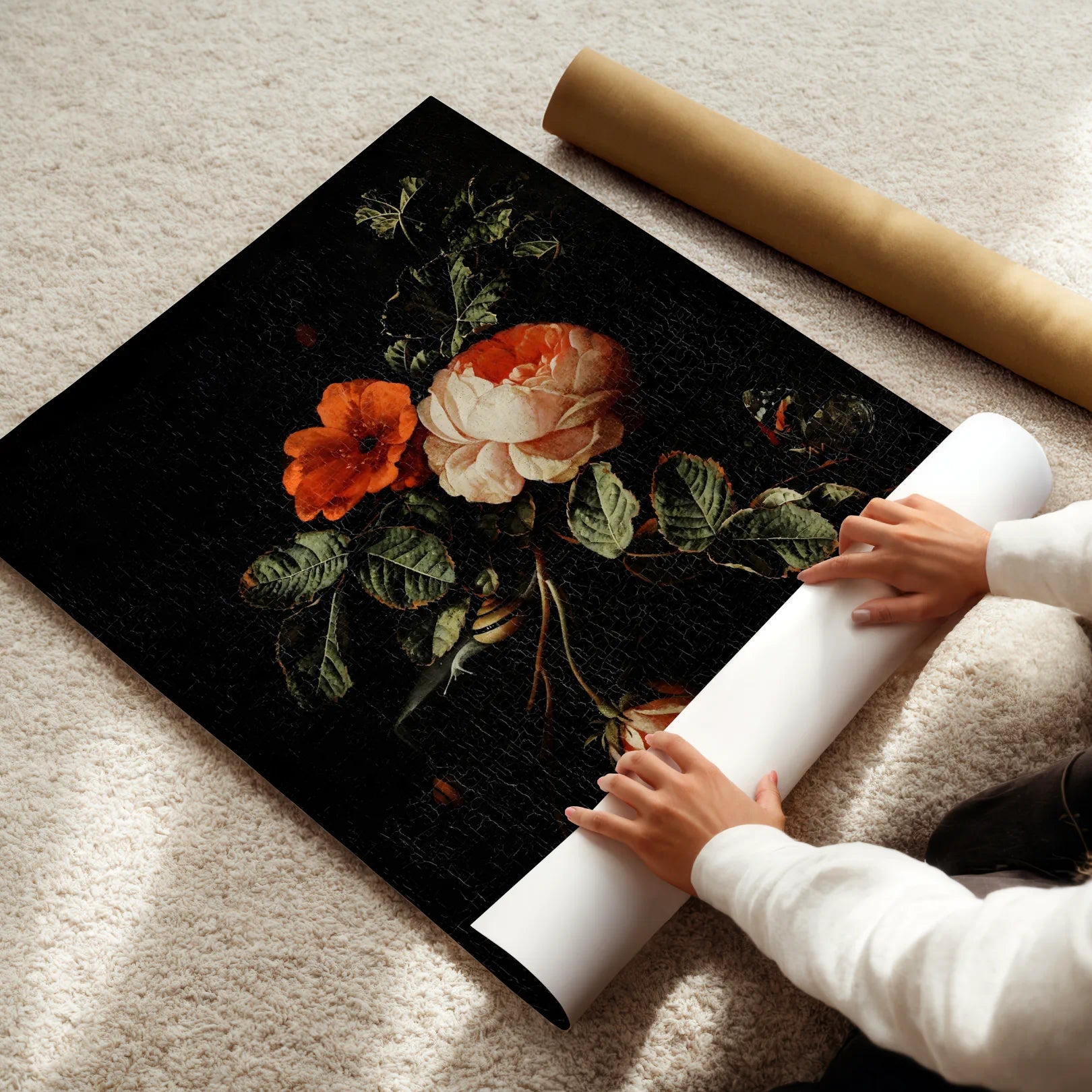 Person unrolling a floral poster on a carpeted floor