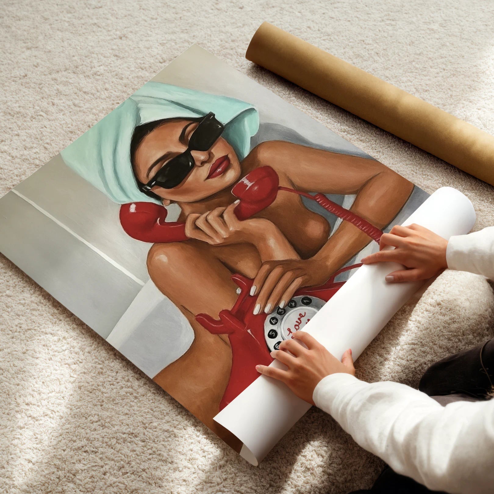 Person unrolling a poster of a woman on a phone with a towel on her head.