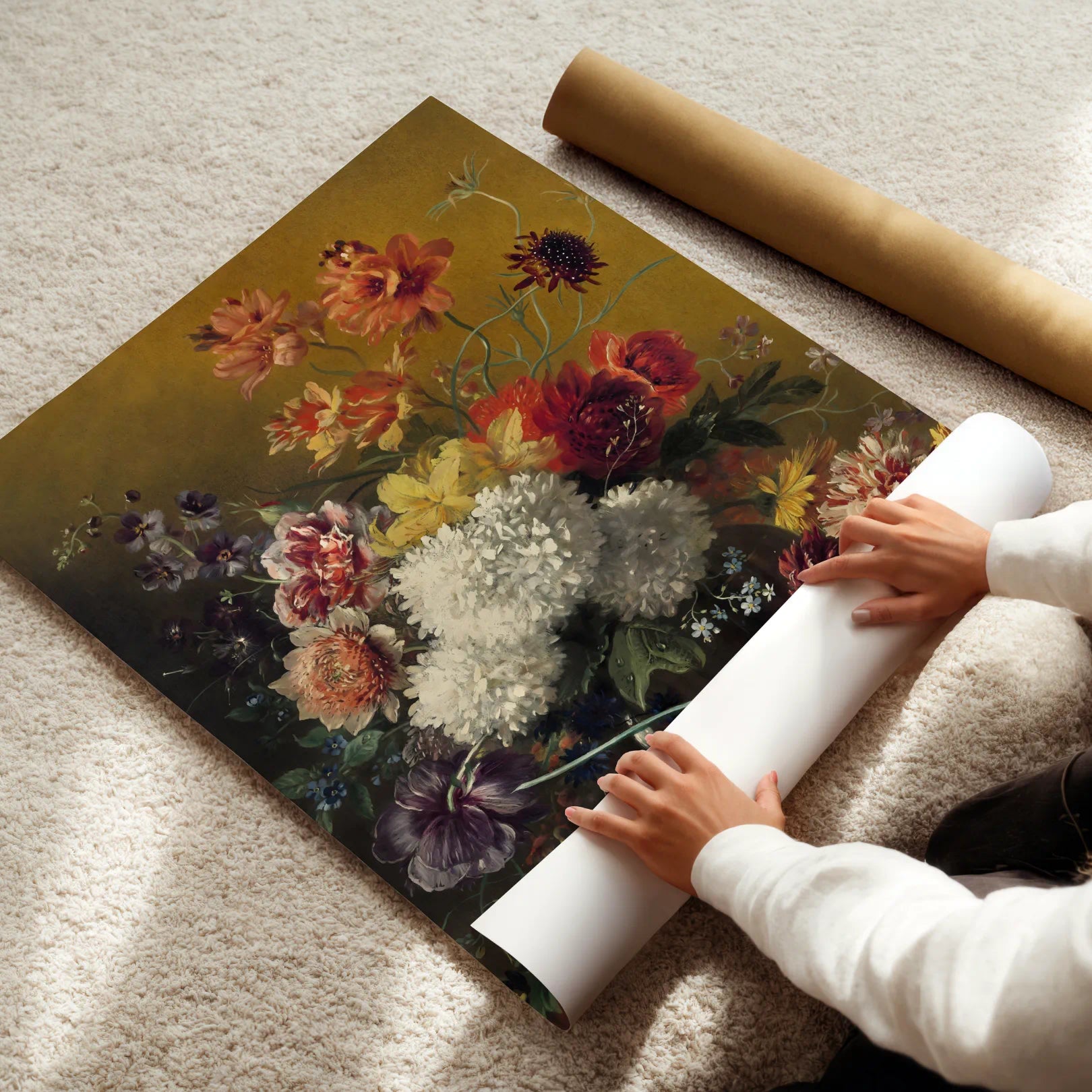 Person unrolling a floral poster on a carpeted floor