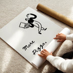 Person unrolling a large poster with a graphic and text on a carpeted floor.