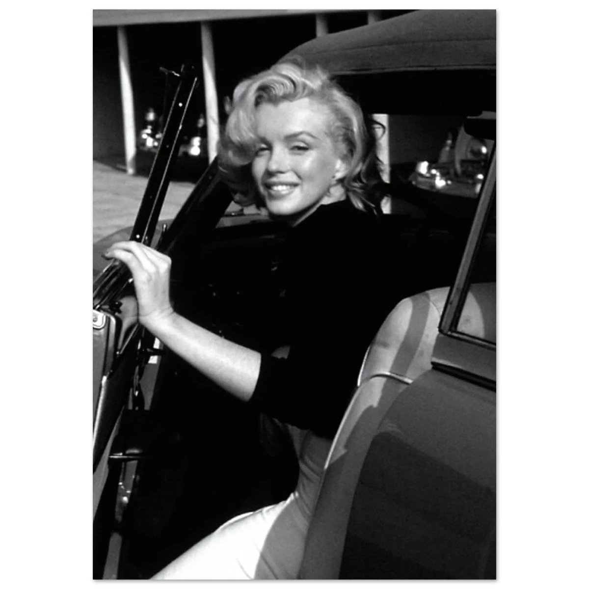 Black and white photo of Marilyn Monroe sitting in a car