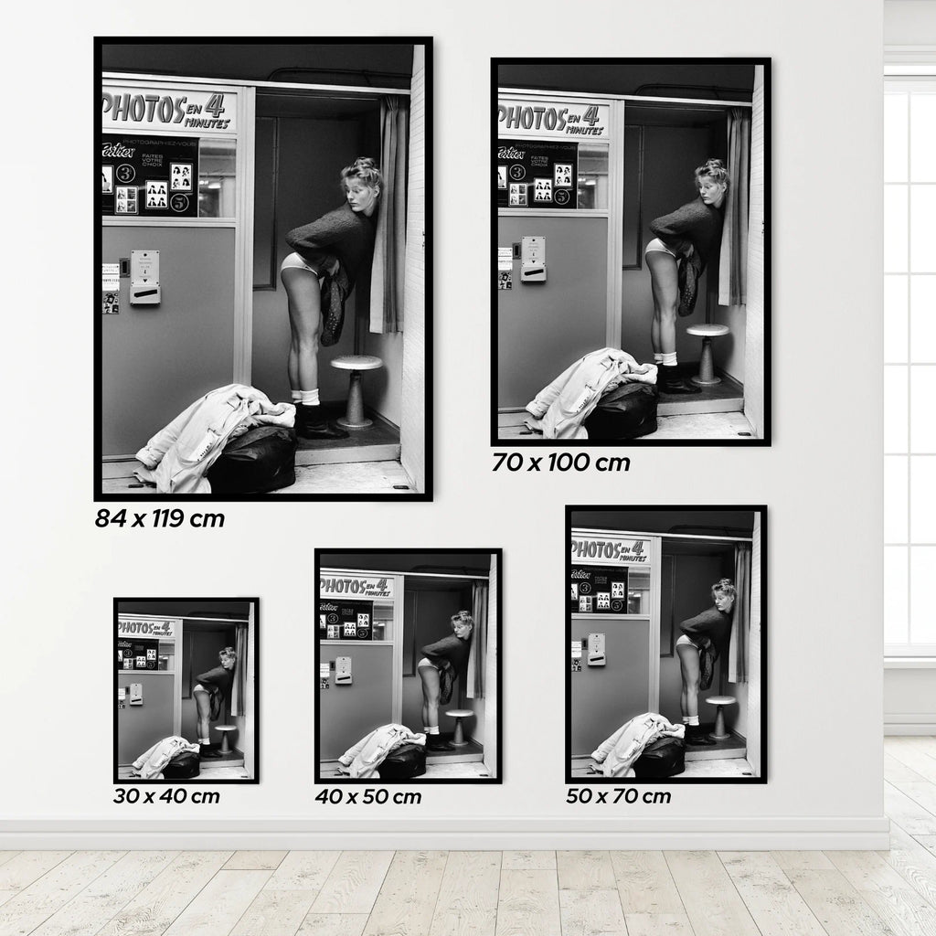 Set of a woman in a Photo Booth framed black and white posters on a wall with dimensions displayed.