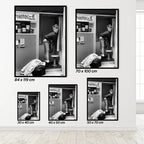 Set of a woman in a Photo Booth framed black and white posters on a wall with dimensions displayed.