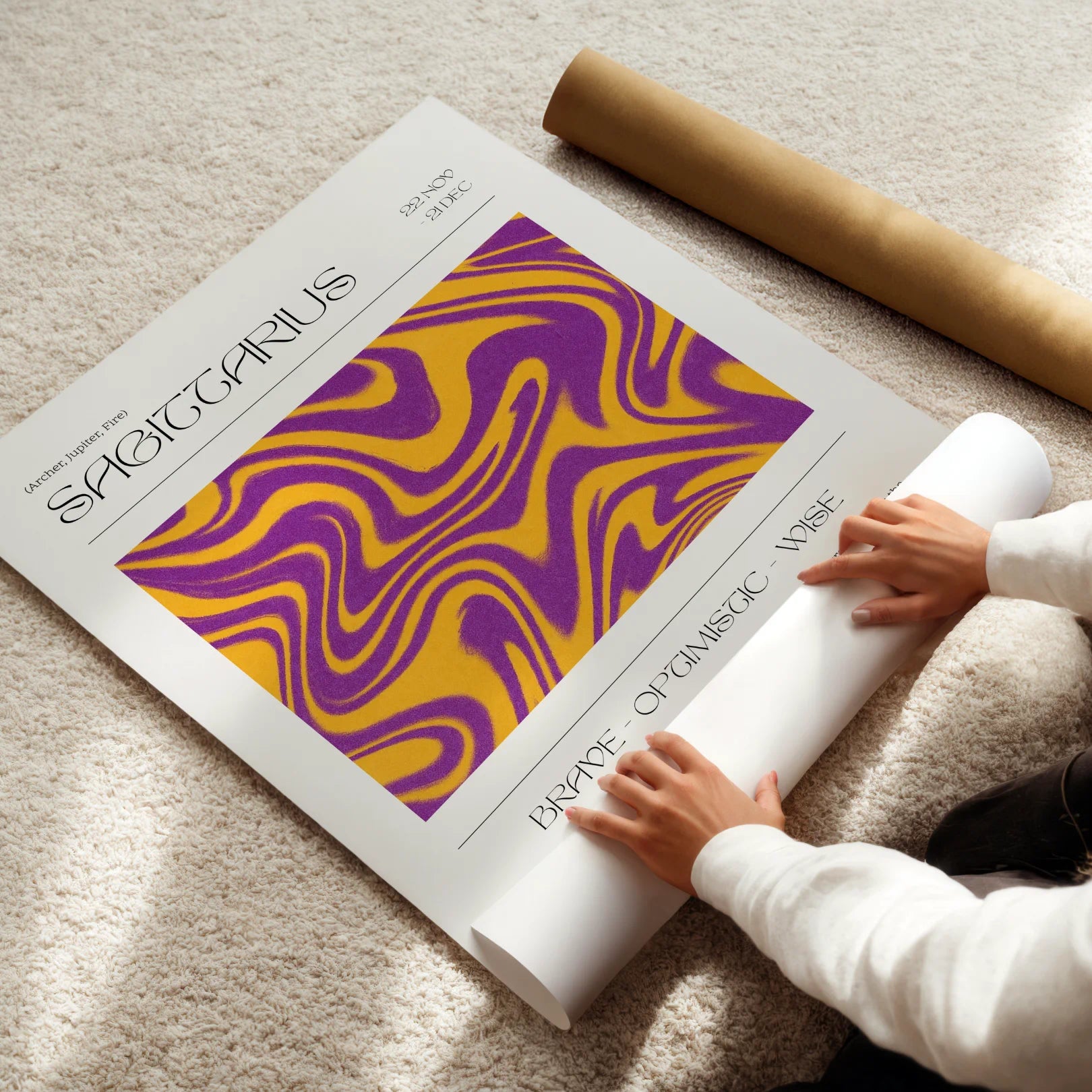 Person unrolling a sagittarius zodiac-themed poster with a purple and yellow design on a beige carpet.
