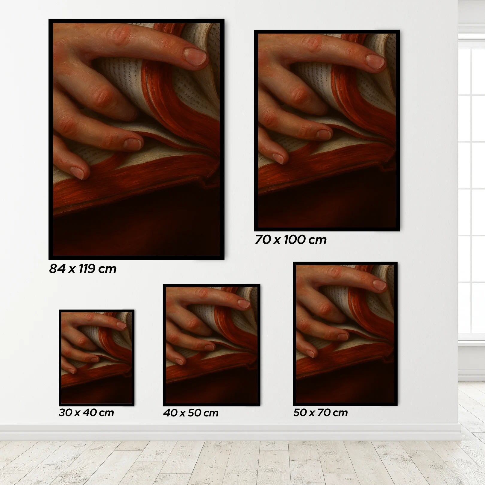 Set of wall art prints showing different sizes of a hand holding a book.