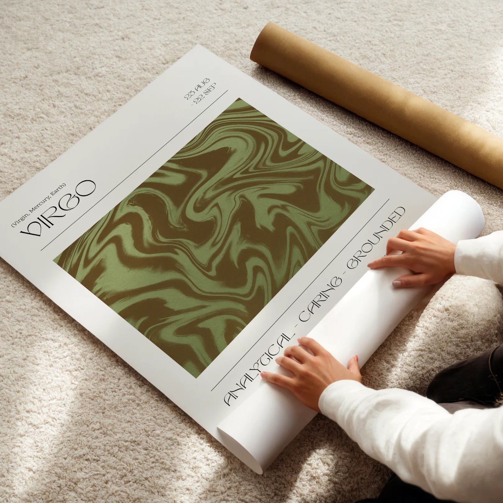 Person unrolling a astrological poster titled 'Virgo' on a light-colored floor.