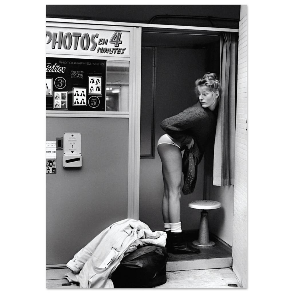 Black and white photo of a woman in a photo booth with 'PHOTOS EN 4 MINUTES' sign.