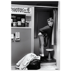 Black and white photo of a woman in a photo booth with 'PHOTOS EN 4 MINUTES' sign.